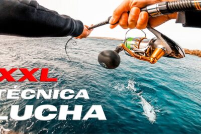 Manos sujetando una caña y carrete mientras se lucha por una captura en el mar 8PmwVdhRkBM.