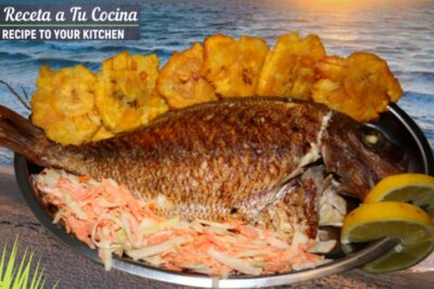 Pargo frito entero con tostones, ensalada rallada y rodajas de limón sobre bandeja frente al mar JKauFk9 kew