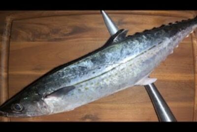 Pescado entero sobre tabla de madera con cuchillos, KffmEC YUlk