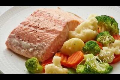 Filete de salmón rosado con brócoli, coliflor y zanahorias en plato blanco