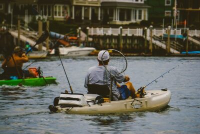 Kayak de pesca con cañas, red y equipo visible mostrando accesorios pesca kayak mejores opciones