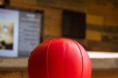 Primer plano de una pelota roja de cuero con costuras, imagen conceptual para bagres comunes en mi area