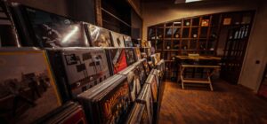 Interior de tienda de vinilos vintage con estanterías de discos y luz cálida como fomentar colaboracion industria pesquera conservacionistas