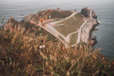 Vista aérea de un cabo con senderos, zonas de césped y costa rocosa, consejos eficientes anclar kayak pesco.