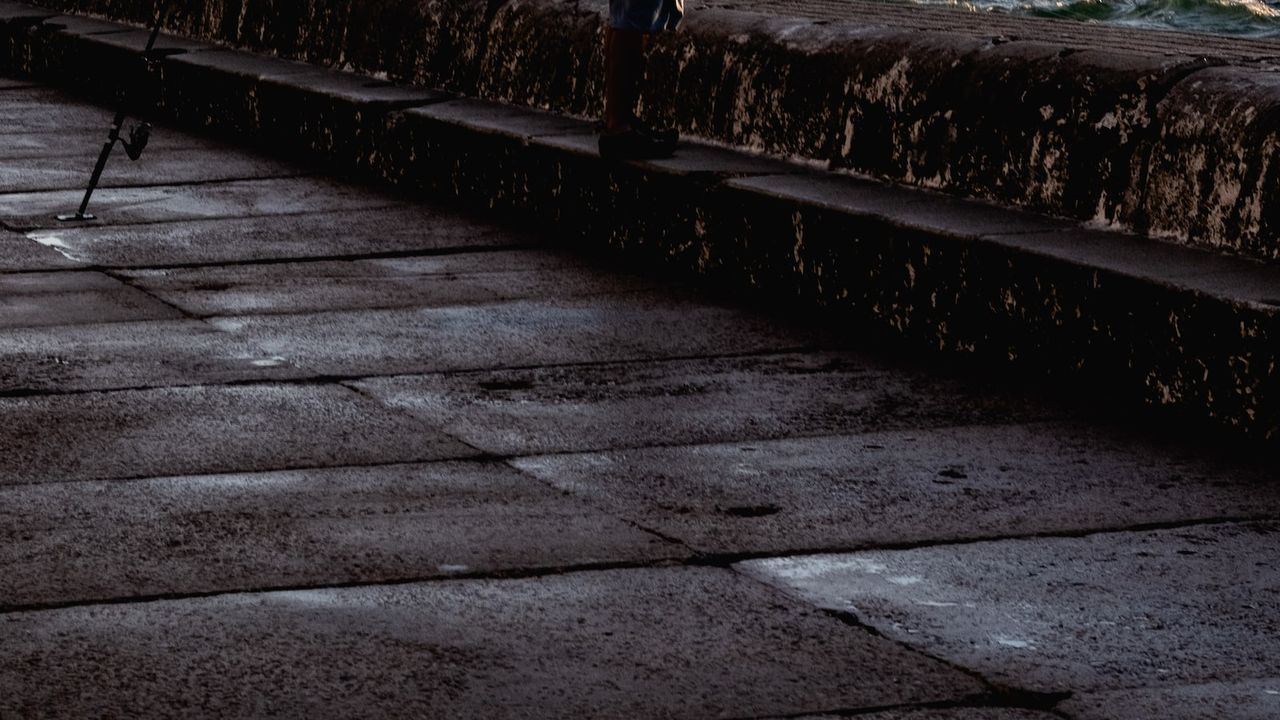 Muelle con superficie mojada y caña apoyada, imagen pensada para consejos pescar kayak rios arroyos