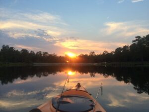 Kayak con cañas sobre un lago al amanecer, descubre mejores lugares pescar kayak cerca.