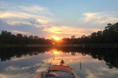 Kayak con cañas sobre un lago al amanecer, descubre mejores lugares pescar kayak cerca.