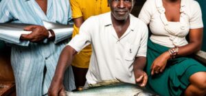 Pescadores y vecina muestran una gran captura que refleja el impacto pesca sostenible comunidades costeras.