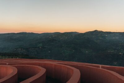 Vista panorámica de montañas al atardecer con una estructura circular en primer plano, imagen ideal para contenidos sobre el mejor cebo para pescar lucio consejos efectivos y comprobados