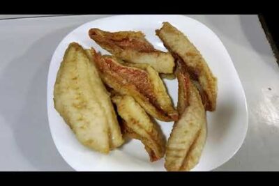 Piezas de pescado frito dorado fqnjS4Ho2S4 sobre un plato blanco