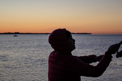 Silueta de un pescador con caña al atardecer frente al mar, guia guardar capturas pesca kayak