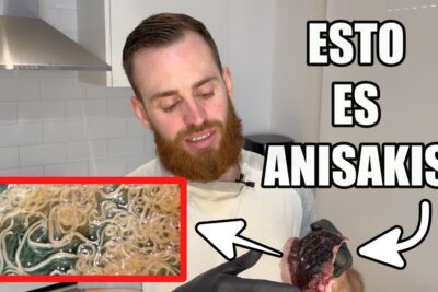 Hombre con barba en cocina sosteniendo órgano de pescado con gusanos blanquecinos visibles iXiTL5heP60