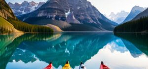 Cuatro kayaks coloridos alineados en la orilla de un lago de montaña con agua en calma y reflejos, la mejor forma de guardar tu kayak para evitar danos guia completa.