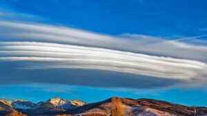 Cielo azul con nubes lenticulares sobre montañas nevadas, la tecnica efectiva pescar truchas consejos trucos