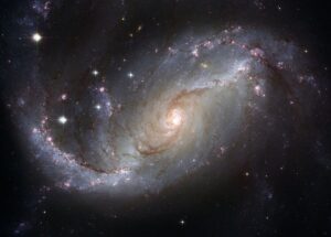 Galaxia espiral brillante con núcleo dorado y brazos en remolino llenos de polvo estelar y cúmulos de formación estelar linea pesca mosca agua salada pez espada