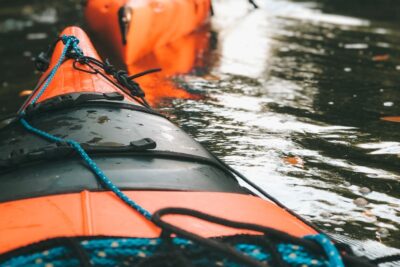 Kayak anaranjado con gotas de agua y cuerdas sobre la cubierta, ilustración de los mejores metodos para secar tu kayak de pesca.
