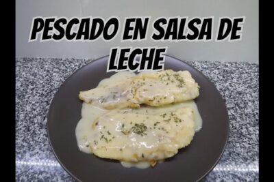 Dos filetes de pescado cubiertos con salsa blanca cremosa y hierbas