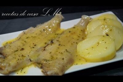 Filetes de pescado blanco con salsa amarilla brillante y patatas en rodajas mSw5UXUPZfk