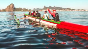 Grupo en embarcación larga con remos y palas sobre aguas tranquilas mostrando mejores remos pesca kayak