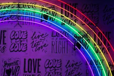 Arcoíris de luces de neón multicolor sobre pared con mensajes 'LOVE', mejores senuelos pesca truchas arcoiris