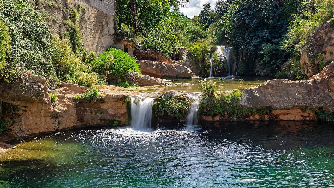 Cascadas y poza en río rocoso con vegetación, recordando precauciones pescar areas corrientes fuertes