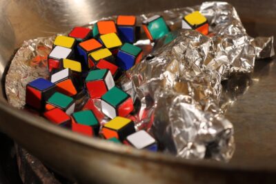 Mini cubos de rompecabezas multicolores en una sartén con papel de aluminio