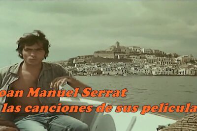 Fotograma vintage rZyfCTh1Yh8 de un hombre en una barca con un pueblo costero al fondo.