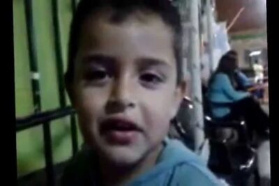Primer plano de un niño con sudadera azul sonriendo en un entorno interior tlCq FzpKM0