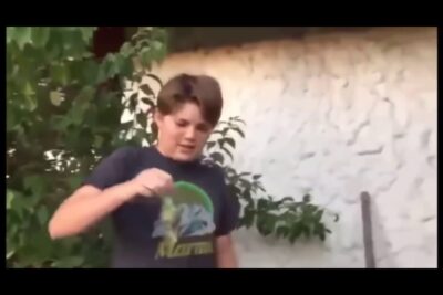 Adolescente al aire libre mirando y sosteniendo un pequeño objeto verde u7vxxKEh JU.